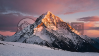 雪山黎明，霞光洒落，雪峰宁静，美不胜收。